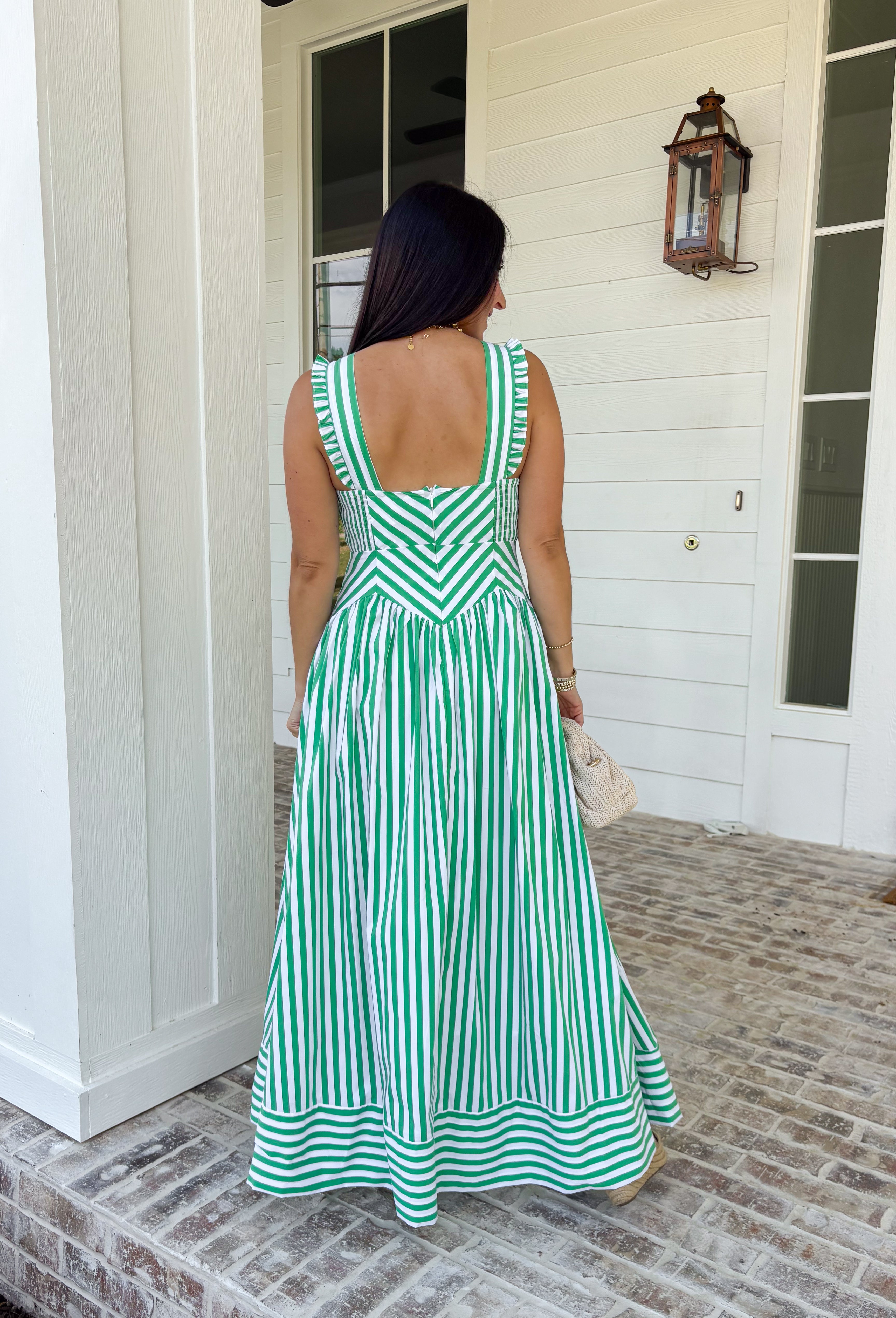 Fresh, crisp, and made for sunny days! This green and white stripe sleeveless midi dress brings a clean, classic look with just the right touch of femininity. The subtle ruffle detail along the sleeves adds a soft, playful feel, while the tailored silhouette keeps it polished and easy to wear. Designed with a hint of stretch and smocking along the back, this dress offers a comfortable, flattering fit. 