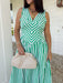 Fresh, crisp, and made for sunny days! This green and white stripe sleeveless midi dress brings a clean, classic look with just the right touch of femininity. The subtle ruffle detail along the sleeves adds a soft, playful feel, while the tailored silhouette keeps it polished and easy to wear. Designed with a hint of stretch and smocking along the back, this dress offers a comfortable, flattering fit. 