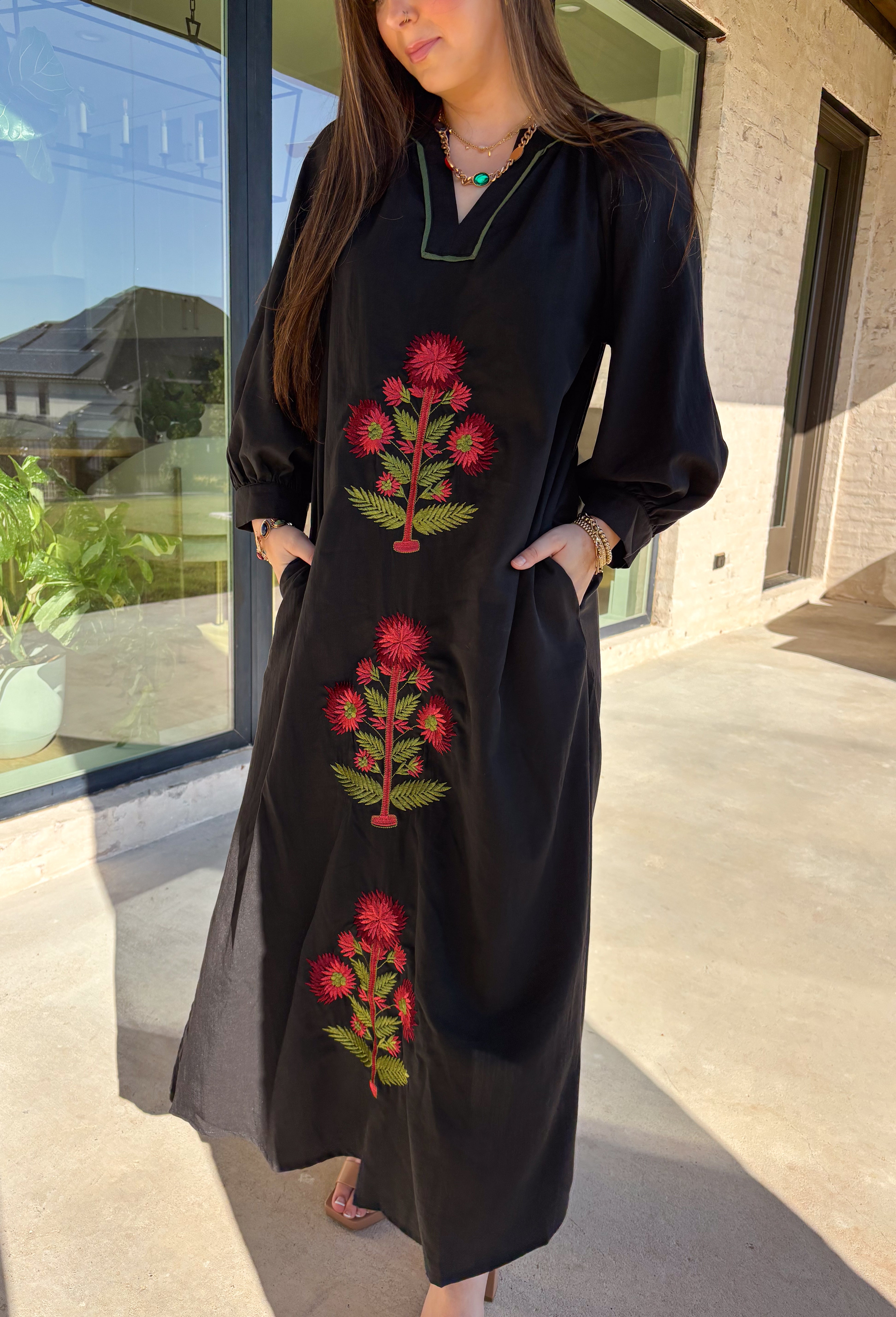 Bring elegance to the winter season with this stunning black embroidered midi dress by Entro. Featuring beautiful burgundy and olive floral embroidery, this long sleeve dress combines cozy sophistication with timeless charm. The contrast trim v-neck and subtle side slits add a touch of movement, while the fully lined design ensures comfort and warmth. Perfect for winter gatherings, holiday dinners, or date nights, this dress is effortlessly refined for the season.