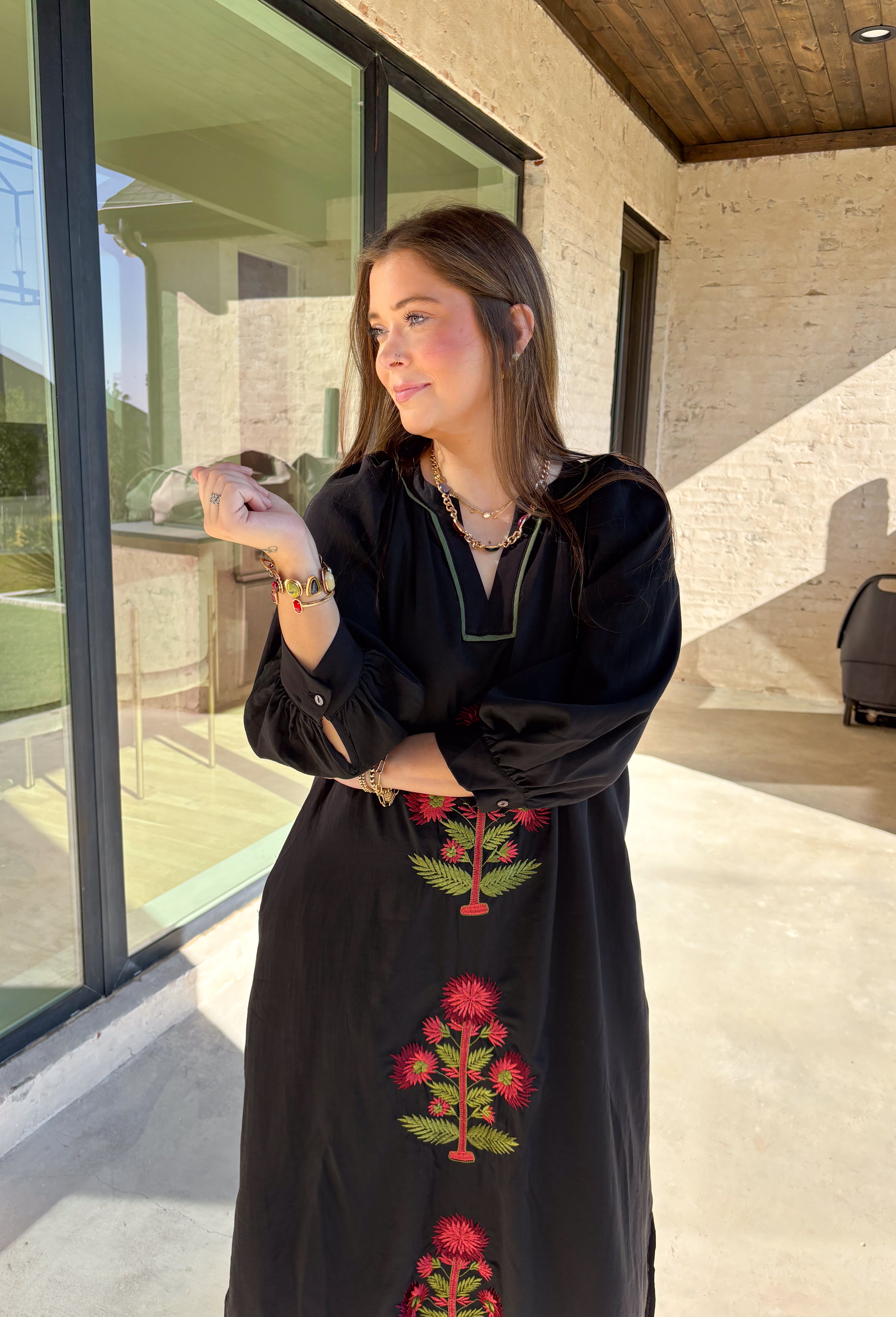 Bring elegance to the winter season with this stunning black embroidered midi dress by Entro. Featuring beautiful burgundy and olive floral embroidery, this long sleeve dress combines cozy sophistication with timeless charm. The contrast trim v-neck and subtle side slits add a touch of movement, while the fully lined design ensures comfort and warmth. Perfect for winter gatherings, holiday dinners, or date nights, this dress is effortlessly refined for the season.