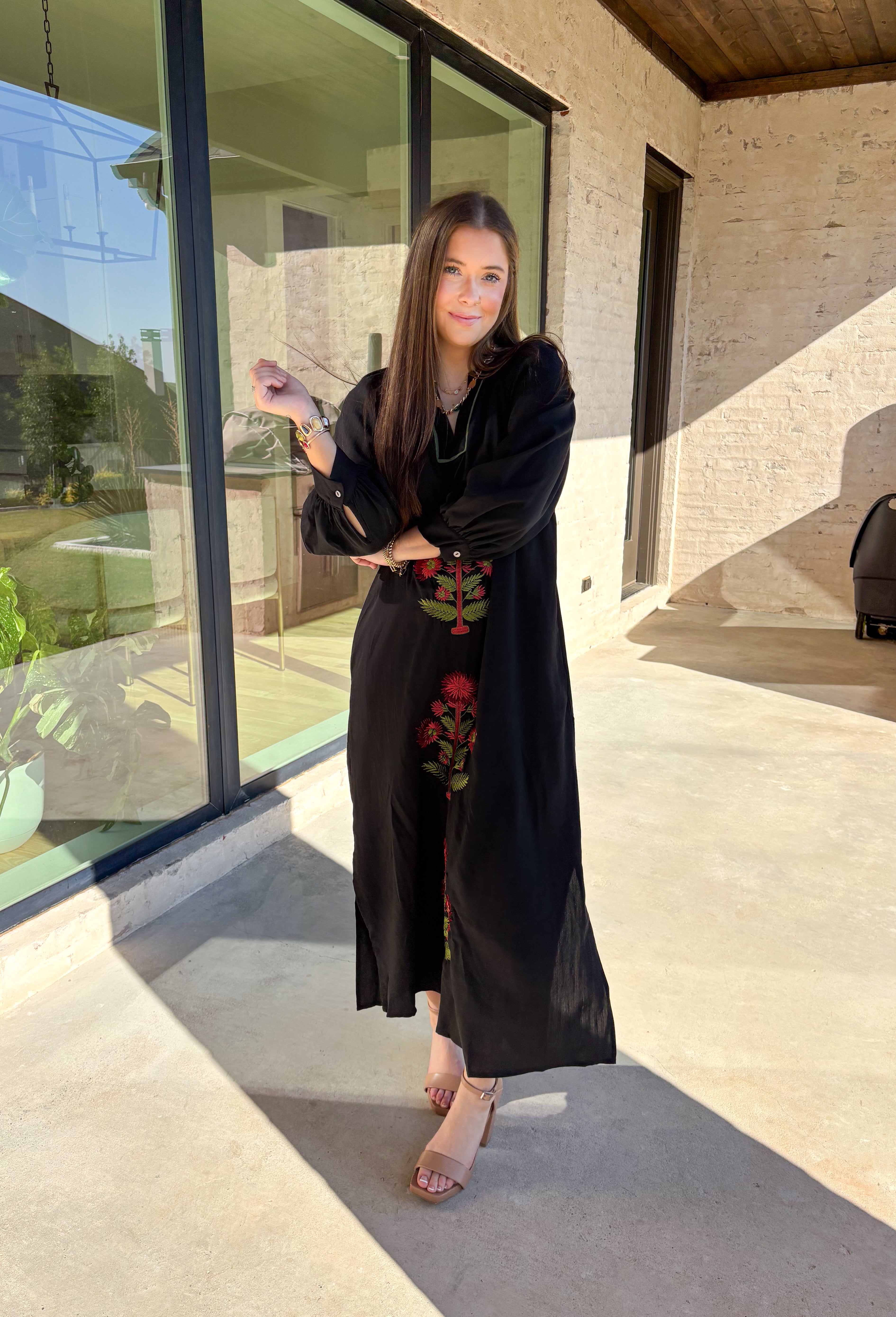 Bring elegance to the winter season with this stunning black embroidered midi dress by Entro. Featuring beautiful burgundy and olive floral embroidery, this long sleeve dress combines cozy sophistication with timeless charm. The contrast trim v-neck and subtle side slits add a touch of movement, while the fully lined design ensures comfort and warmth. Perfect for winter gatherings, holiday dinners, or date nights, this dress is effortlessly refined for the season.