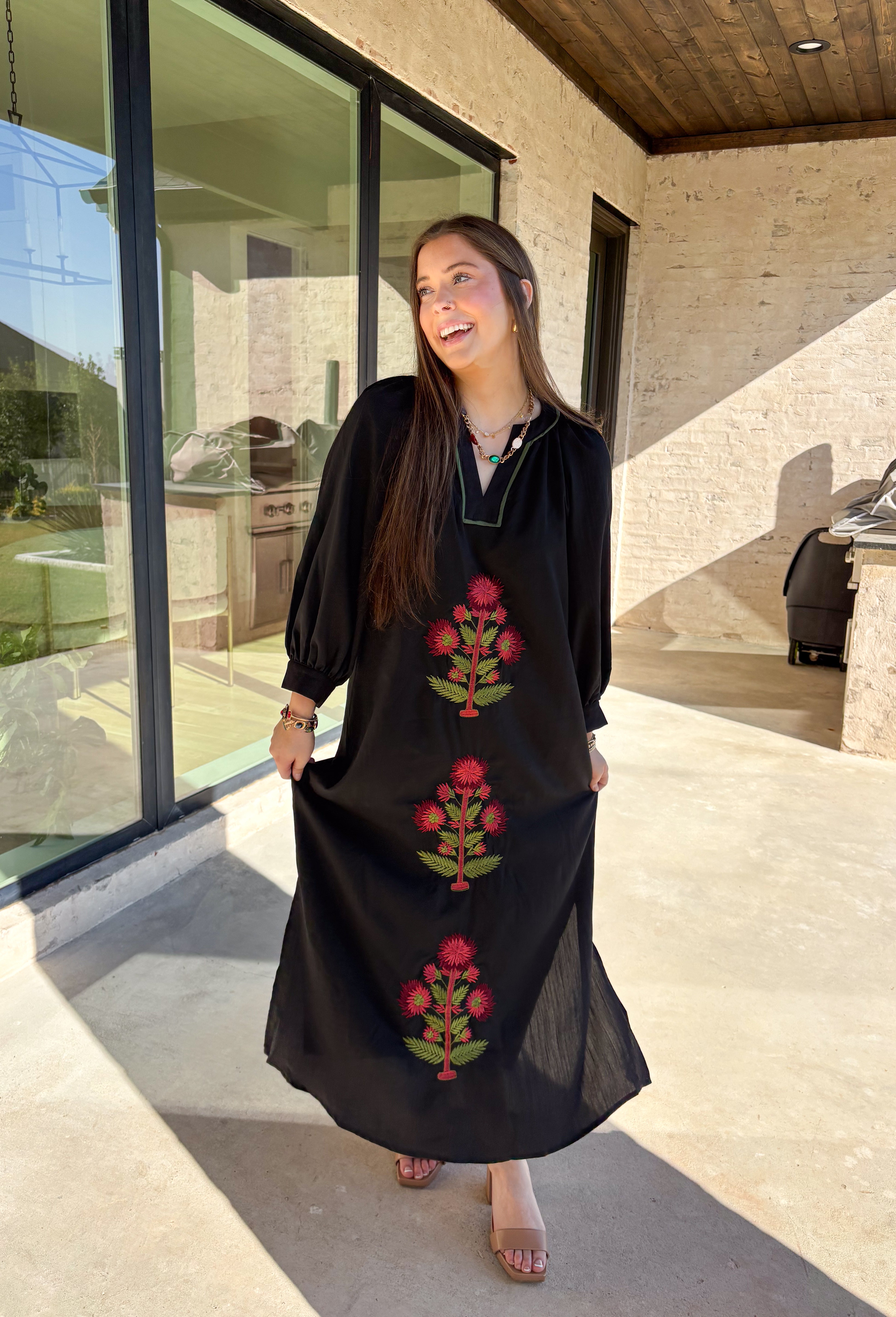 Bring elegance to the winter season with this stunning black embroidered midi dress by Entro. Featuring beautiful burgundy and olive floral embroidery, this long sleeve dress combines cozy sophistication with timeless charm. The contrast trim v-neck and subtle side slits add a touch of movement, while the fully lined design ensures comfort and warmth. Perfect for winter gatherings, holiday dinners, or date nights, this dress is effortlessly refined for the season.