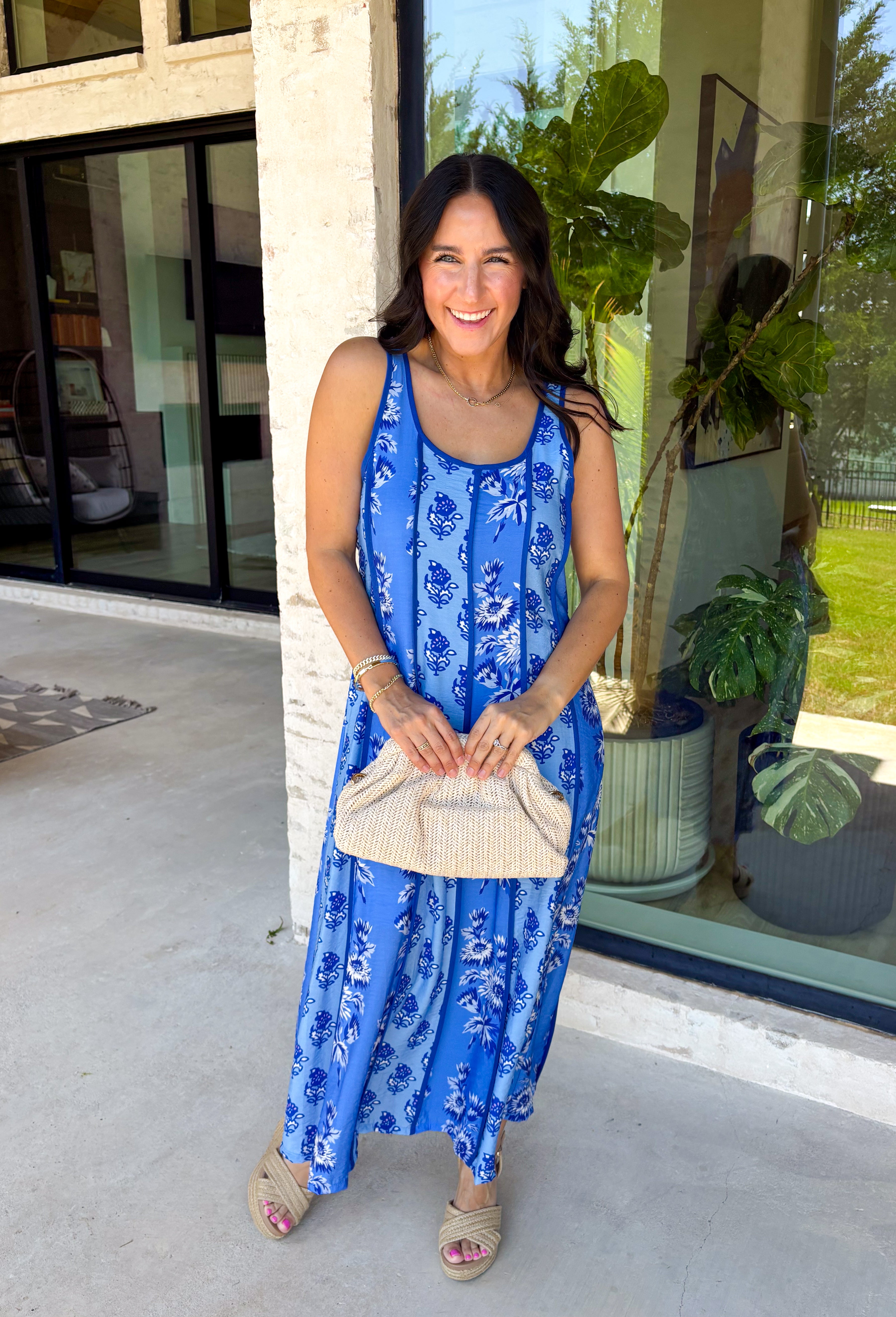 Feminine, fresh, and perfect for sunny days! This sleeveless blue midi dress features a beautiful floral print that feels soft and romantic. Darker blue trim paneling throughout adds a lovely contrast that highlights the silhouette and gives the dress a little extra detail. Smocking along the back and on the back straps creates a comfortable, flexible fit while keeping the shape flattering. 