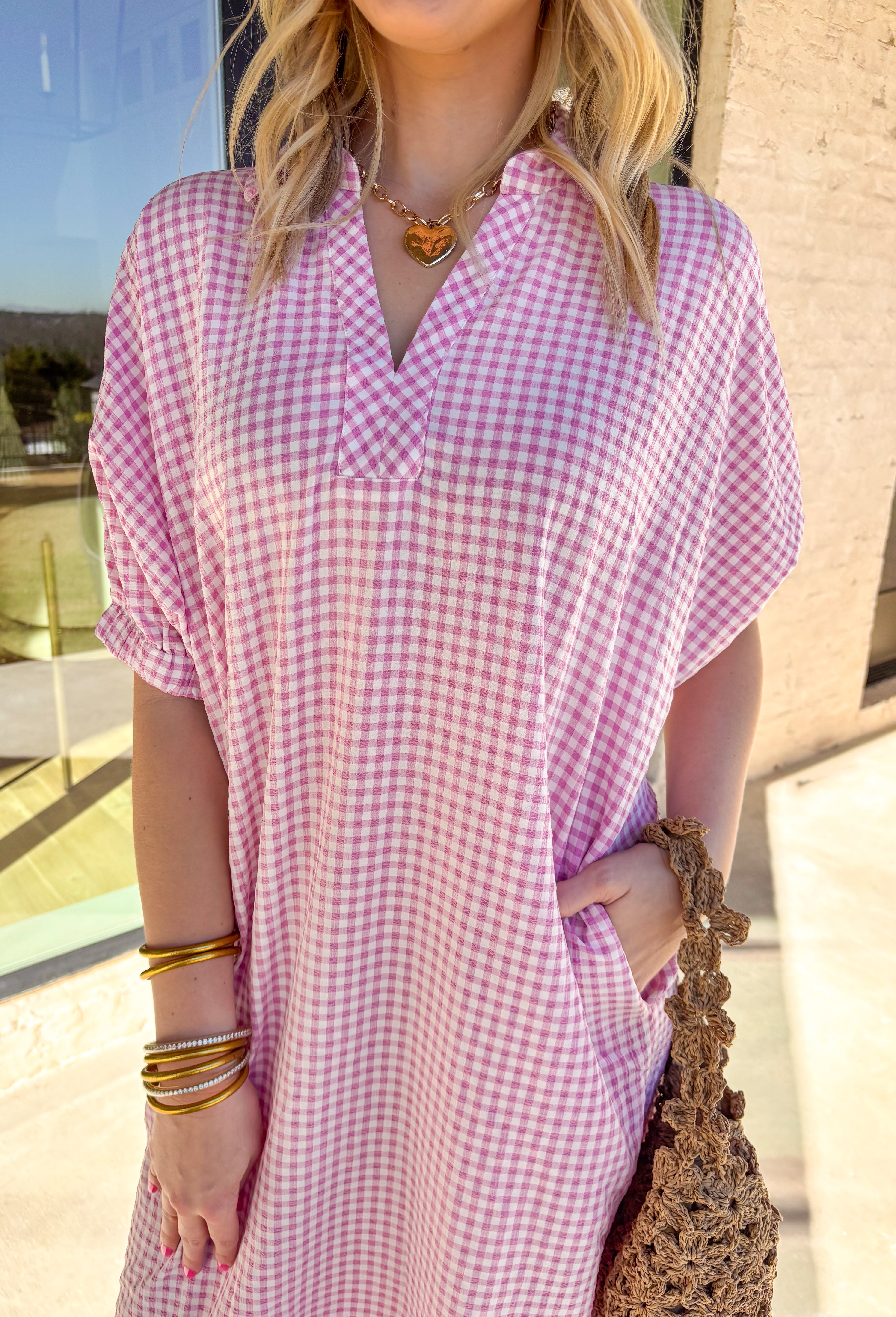 Sweet, classic, and perfect for spring days, this pink and white mini gingham midi dress is an effortless favorite. The timeless gingham print feels fresh and cheerful, while the collared neckline adds a polished touch. Elastic short sleeves keep it comfortable and easy to wear, and side pockets make it as practical as it is cute. With a flattering midi length and lightweight feel, this dress is ready for everything from brunch to casual spring outings.