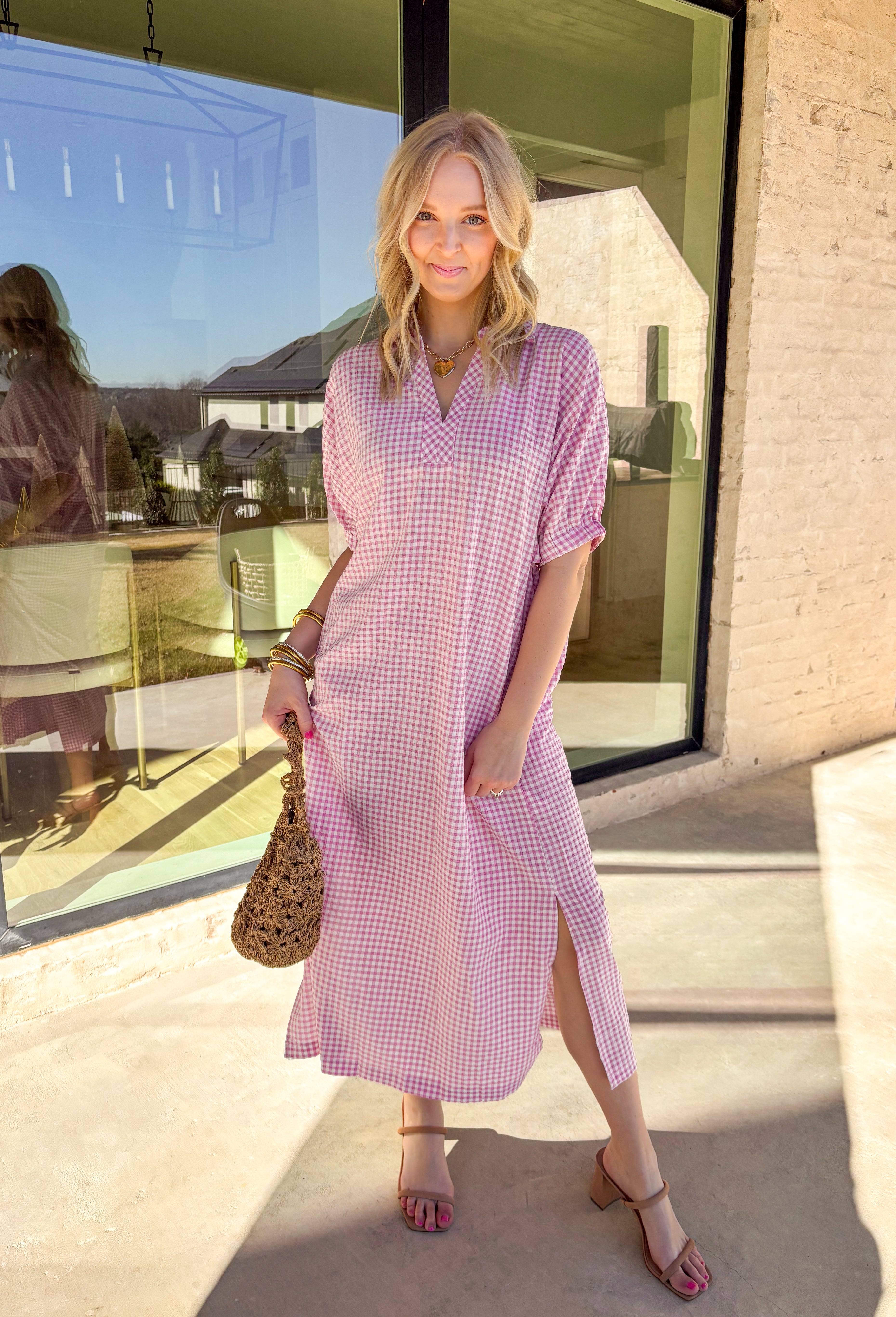 Sweet, classic, and perfect for spring days, this pink and white mini gingham midi dress is an effortless favorite. The timeless gingham print feels fresh and cheerful, while the collared neckline adds a polished touch. Elastic short sleeves keep it comfortable and easy to wear, and side pockets make it as practical as it is cute. With a flattering midi length and lightweight feel, this dress is ready for everything from brunch to casual spring outings.