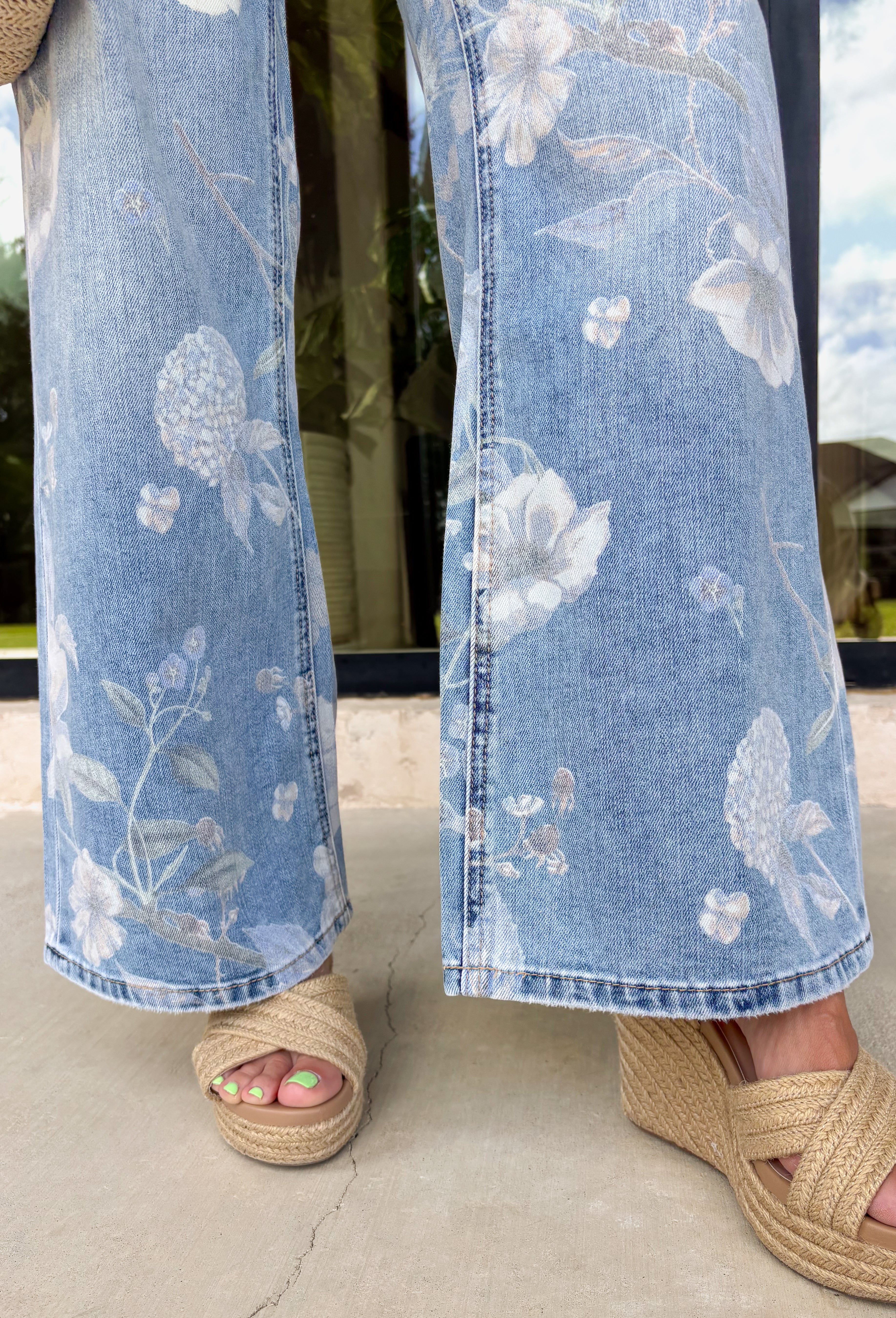 These light wash floral flare jeans are giving major retro summer energy in the best way! Designed with a super high-rise fit and an extreme vintage flare leg, they instantly elongate your silhouette while making a statement. The muted floral print adds a soft, feminine touch that feels unique but still easy to style for everyday wear. Pair them with a simple tank, graphic tee, or lightweight blouse and let the jeans do all the talking. 