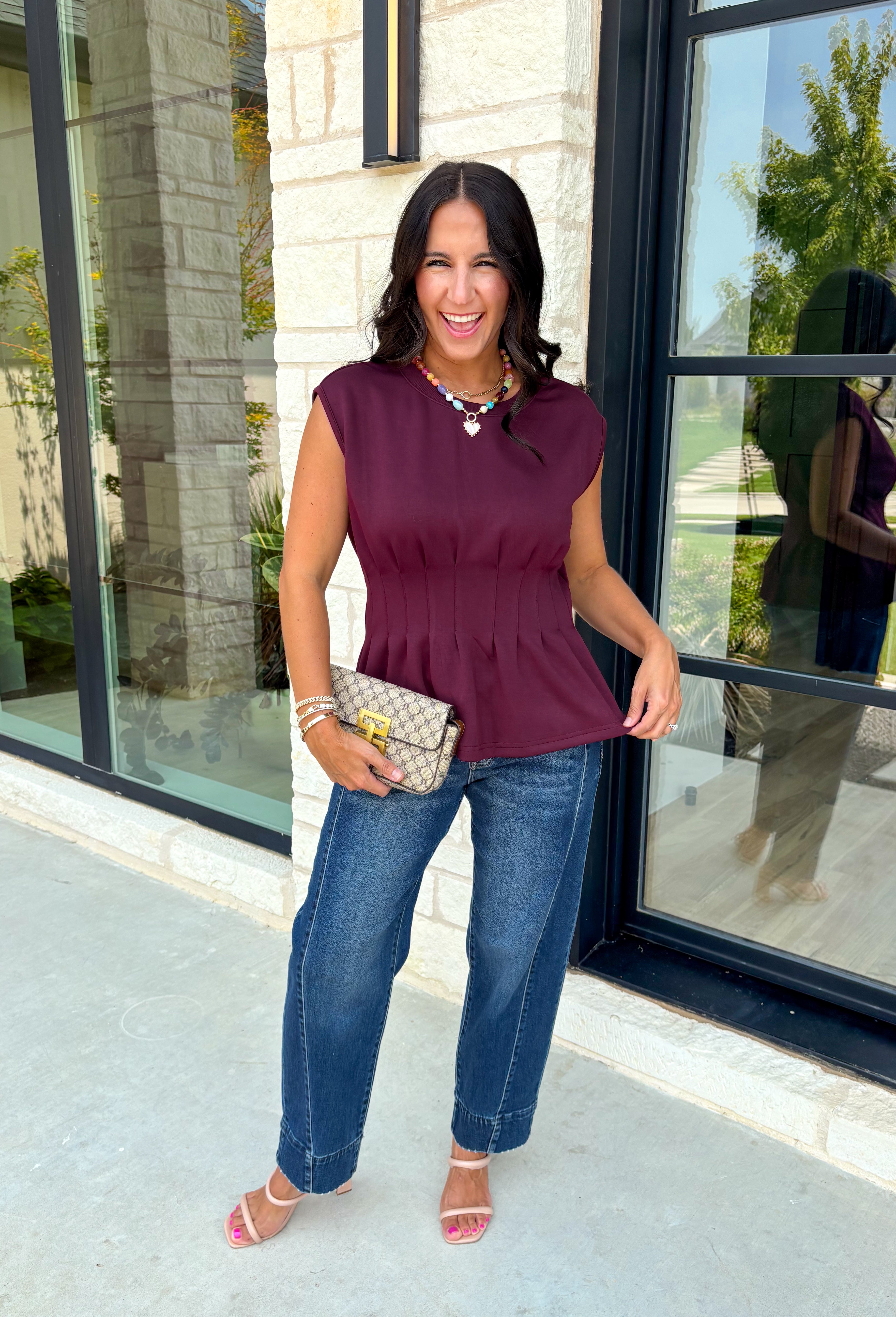 Rich seasonal color meets effortless style in this beautiful burgundy sleeveless top. Designed with flattering pleated waist detailing, this timeless piece creates a polished silhouette that's easy to dress up or down. The soft knit fabric offers all-day comfort, making it perfect for layering under blazers and jackets throughout the fall or wearing on its own during warmer autumn afternoons. 