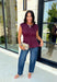 Rich seasonal color meets effortless style in this beautiful burgundy sleeveless top. Designed with flattering pleated waist detailing, this timeless piece creates a polished silhouette that's easy to dress up or down. The soft knit fabric offers all-day comfort, making it perfect for layering under blazers and jackets throughout the fall or wearing on its own during warmer autumn afternoons. 