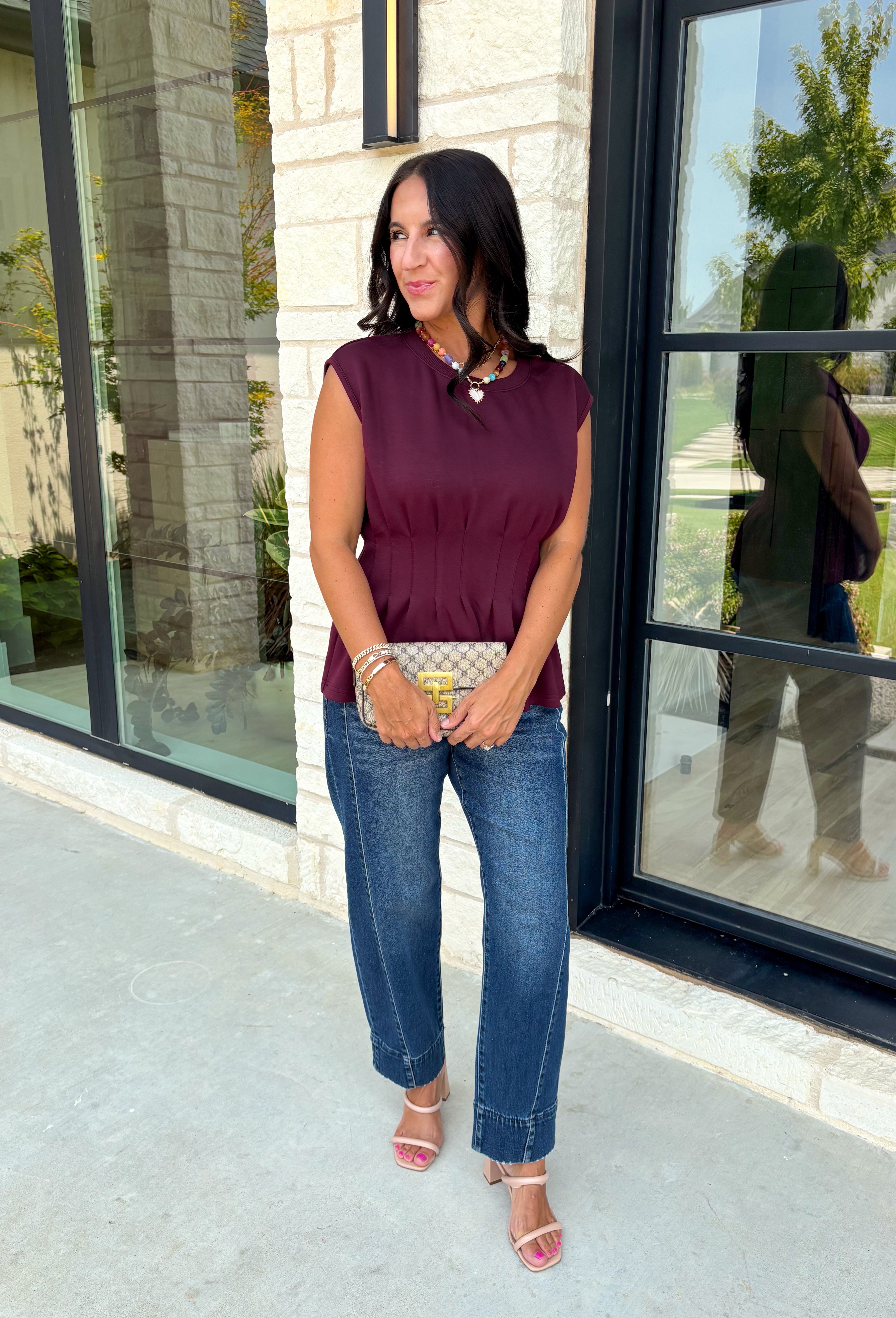 Rich seasonal color meets effortless style in this beautiful burgundy sleeveless top. Designed with flattering pleated waist detailing, this timeless piece creates a polished silhouette that's easy to dress up or down. The soft knit fabric offers all-day comfort, making it perfect for layering under blazers and jackets throughout the fall or wearing on its own during warmer autumn afternoons. 