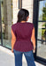 Rich seasonal color meets effortless style in this beautiful burgundy sleeveless top. Designed with flattering pleated waist detailing, this timeless piece creates a polished silhouette that's easy to dress up or down. The soft knit fabric offers all-day comfort, making it perfect for layering under blazers and jackets throughout the fall or wearing on its own during warmer autumn afternoons. 