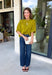 A rich olive green gets a pretty update with this pearl-detailed short sleeve sweater from Glam. Pearl detailing throughout adds a special touch to the soft knit, making it easy to dress up while still keeping that cozy, everyday feel. Exposed hems bring in a relaxed finish, while ribbed detailing along the neckline, sleeve cuffs, and hem gives it a classic sweater look. Wear it to the office, dinner plans, or anytime your outfit could use a little something extra.