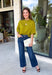 A rich olive green gets a pretty update with this pearl-detailed short sleeve sweater from Glam. Pearl detailing throughout adds a special touch to the soft knit, making it easy to dress up while still keeping that cozy, everyday feel. Exposed hems bring in a relaxed finish, while ribbed detailing along the neckline, sleeve cuffs, and hem gives it a classic sweater look. Wear it to the office, dinner plans, or anytime your outfit could use a little something extra.