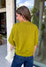 A rich olive green gets a pretty update with this pearl-detailed short sleeve sweater from Glam. Pearl detailing throughout adds a special touch to the soft knit, making it easy to dress up while still keeping that cozy, everyday feel. Exposed hems bring in a relaxed finish, while ribbed detailing along the neckline, sleeve cuffs, and hem gives it a classic sweater look. Wear it to the office, dinner plans, or anytime your outfit could use a little something extra.