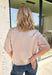 A classic neutral gets a pretty update with this beige short sleeve sweater from Glam. Pearl detailing throughout adds a special touch to the soft knit, making it easy to dress up while still keeping that cozy, everyday feel. Exposed hems bring in a relaxed finish, while ribbed detailing along the neckline, sleeve cuffs, and hem gives it a classic sweater look. Wear it to the office, dinner plans, or anytime your outfit could use a little something extra.