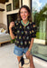 A little bold, a little bright, and totally spring-ready—this black short sleeve top by Entro is the perfect mix of classic and colorful. Featuring a patch floral embroidered print on the front with pops of green, blue, pink, and yellow, it adds beautiful texture and a fun burst of color against the solid black base. The back stays solid black for a clean contrast, and a keyhole closure adds a sweet finishing touch. 