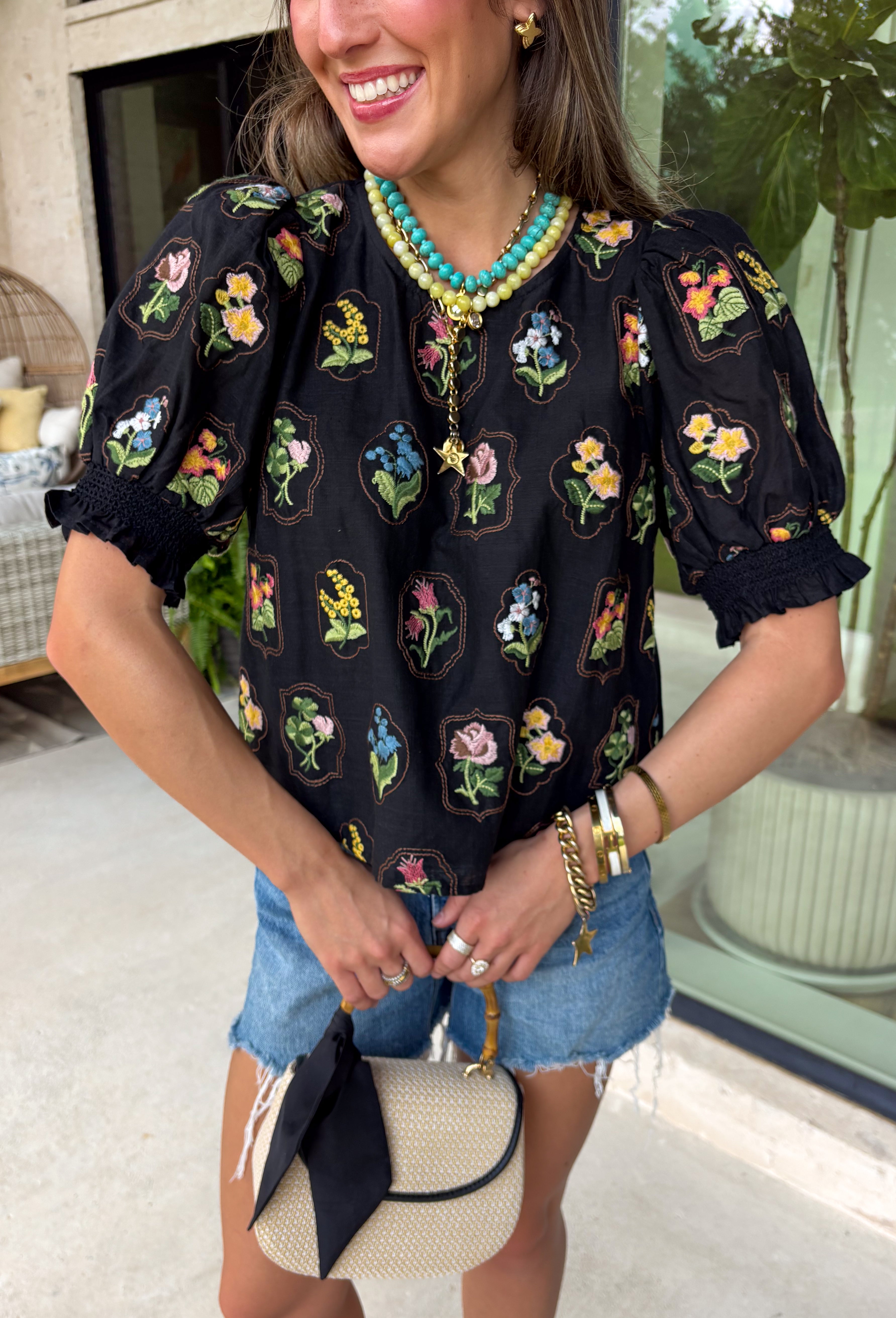 A little bold, a little bright, and totally spring-ready—this black short sleeve top by Entro is the perfect mix of classic and colorful. Featuring a patch floral embroidered print on the front with pops of green, blue, pink, and yellow, it adds beautiful texture and a fun burst of color against the solid black base. The back stays solid black for a clean contrast, and a keyhole closure adds a sweet finishing touch. 