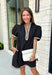 Classic with a modern twist, this black dress is the definition of effortless fall style. Classic black is beautifully accented with tan and cream trim along the front, sides, hem, and sleeves for a look that feels both timeless and eye-catching. The front button details and soft puff sleeves add just the right amount of charm, while the fully lined design and side pockets make it as comfortable as it is stylish. 
