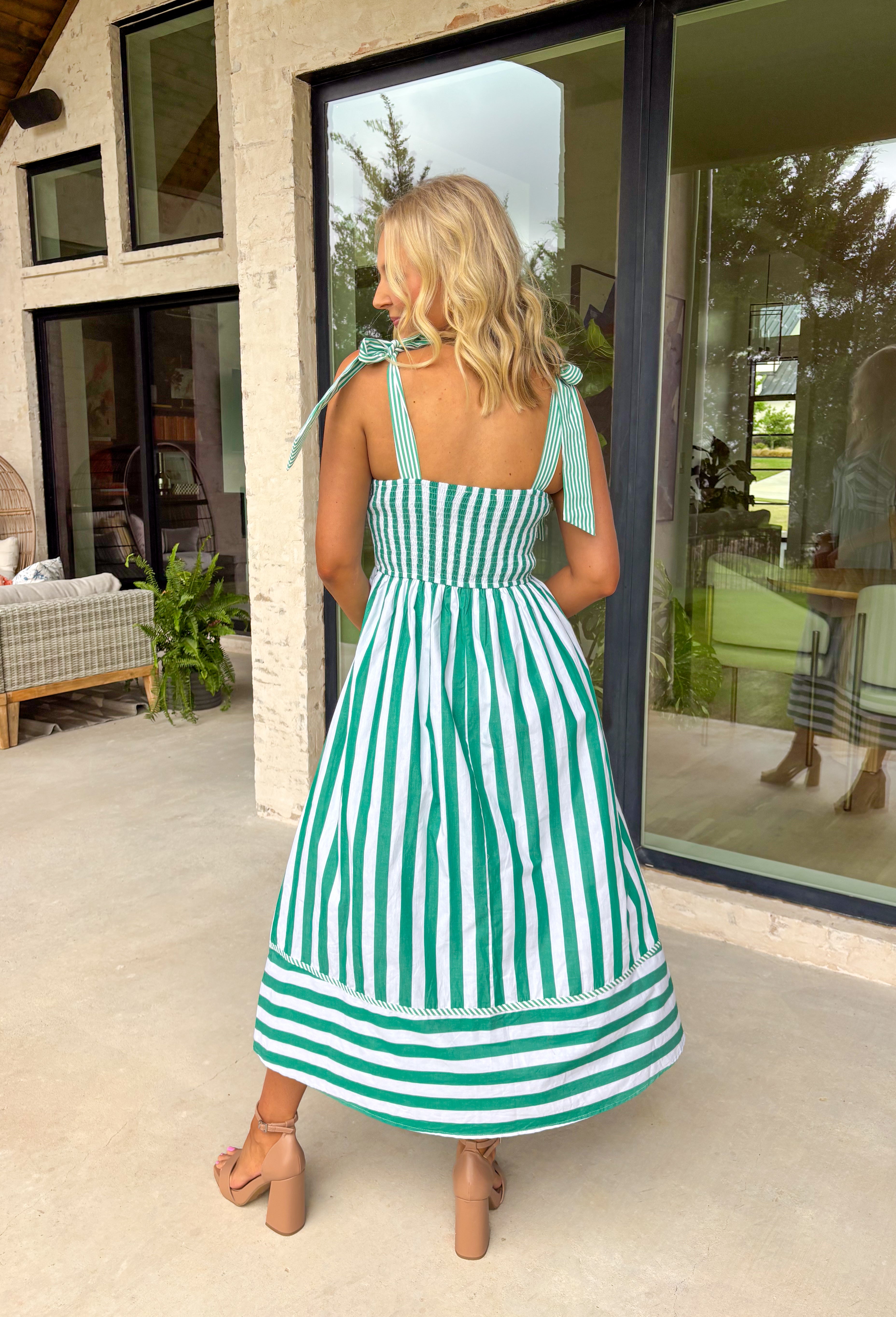 Fresh, playful, and made for sunny spring days, this green and white striped sleeveless midi dress is an effortless standout. The bold large stripe print gives it that classic, crisp look, while the smaller stripe pattern on the adjustable self-tie sleeves and along the front adds a fun contrast detail. Smocking along the back creates a comfortable, flattering fit, and side pockets make it even better (because we love a dress that’s cute and practical). Fully lined and breathable in cotton.