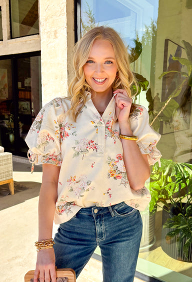 Fresh, playful, and full of spring charm, this off-white short sleeve top by Entro is an easy standout. Designed with a soft, denim-like cotton feel, it features a colorful floral print that brings the perfect pop of seasonal color. The collared neckline keeps it polished, while the statement sleeves with adjustable tie details add a fun, feminine twist. This top is equal parts effortless and eye-catching—perfect for dressing up denim or keeping things casual all spring long.