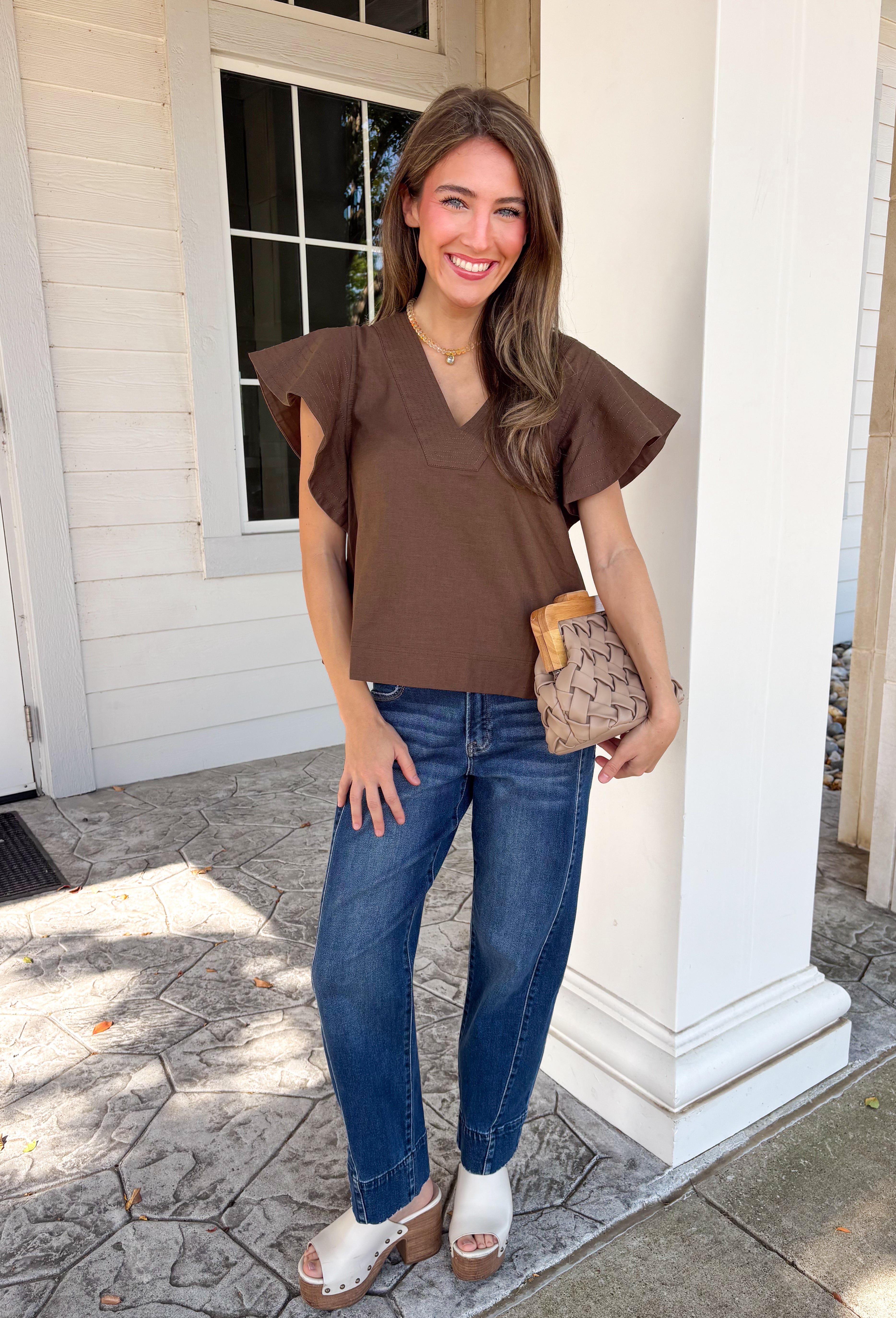 Simple details make all the difference in this effortlessly beautiful brown top! Crafted from a breathable cotton and linen blend, this timeless top is perfect for transitioning through the fall season. The flattering v-neckline is accented with delicate stitch detailing, while flutter sleeves add a soft, feminine touch. A button closure at the back completes the look with subtle charm. 