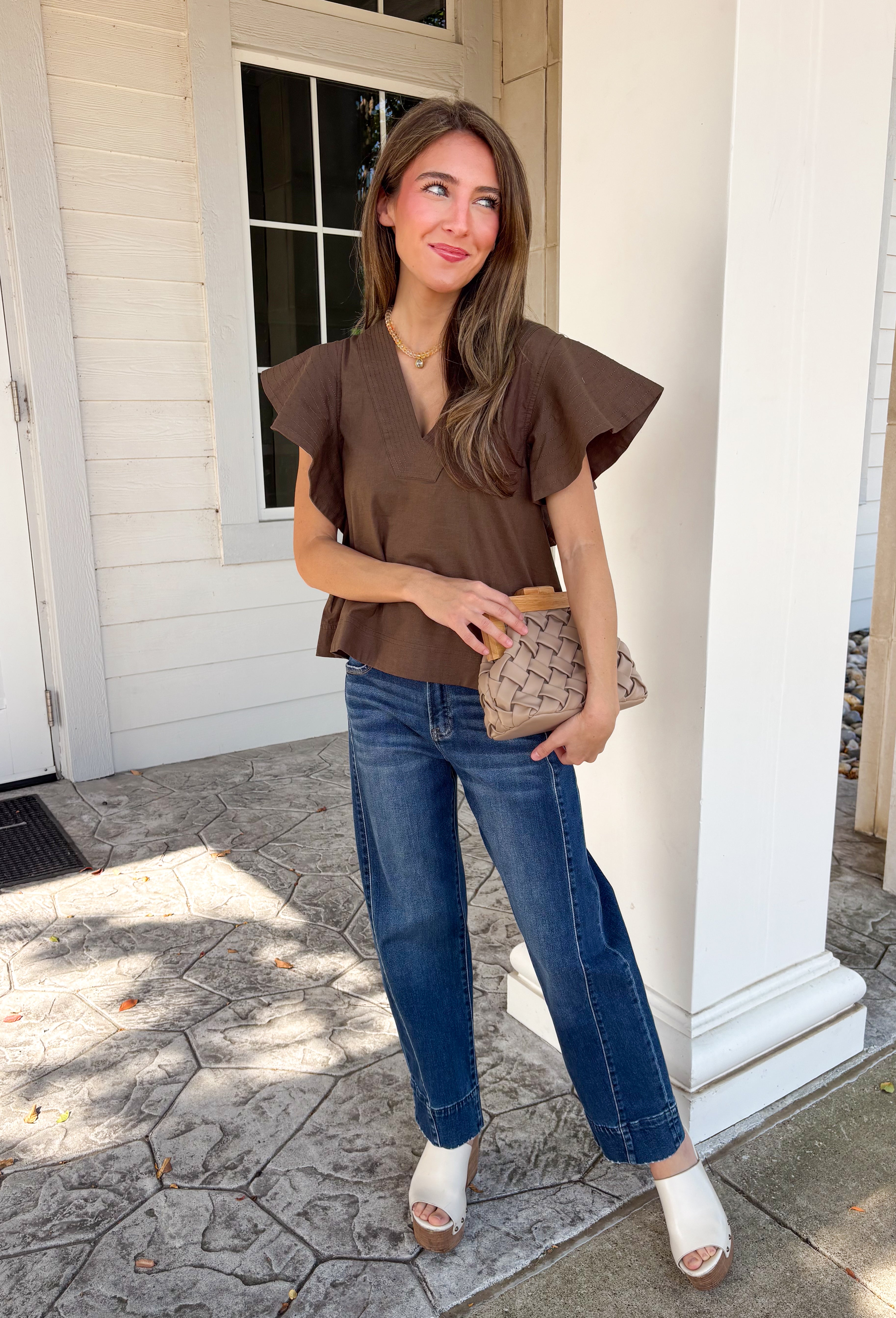 Simple details make all the difference in this effortlessly beautiful brown top! Crafted from a breathable cotton and linen blend, this timeless top is perfect for transitioning through the fall season. The flattering v-neckline is accented with delicate stitch detailing, while flutter sleeves add a soft, feminine touch. A button closure at the back completes the look with subtle charm. 