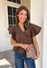 Simple details make all the difference in this effortlessly beautiful brown top! Crafted from a breathable cotton and linen blend, this timeless top is perfect for transitioning through the fall season. The flattering v-neckline is accented with delicate stitch detailing, while flutter sleeves add a soft, feminine touch. A button closure at the back completes the look with subtle charm. 