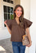 Simple details make all the difference in this effortlessly beautiful brown top! Crafted from a breathable cotton and linen blend, this timeless top is perfect for transitioning through the fall season. The flattering v-neckline is accented with delicate stitch detailing, while flutter sleeves add a soft, feminine touch. A button closure at the back completes the look with subtle charm. 