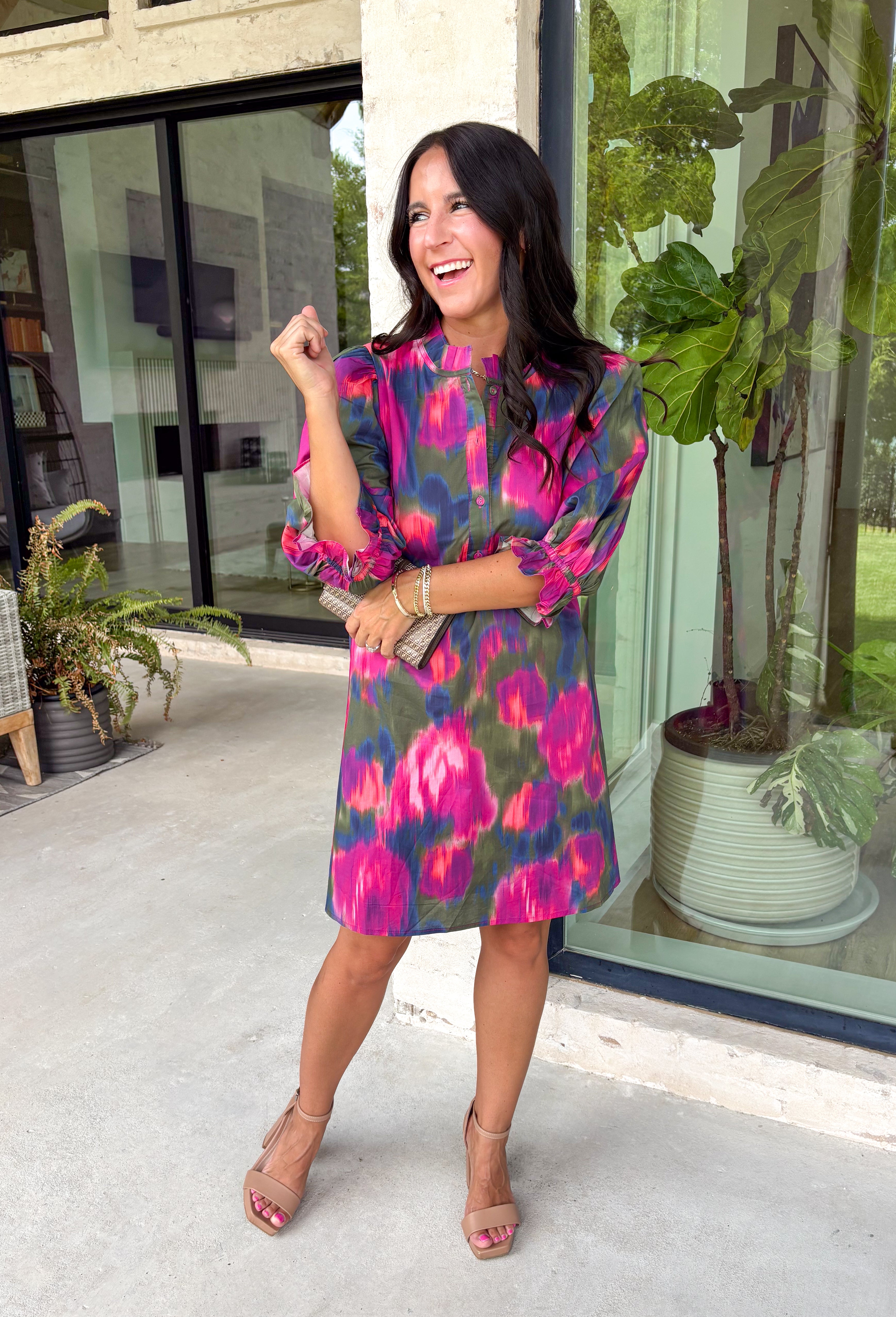 Make every occasion feel a little more special in this beautifully detailed dress from Entro. Featuring a stunning abstract print in rich shades of magenta, olive, navy, and pink, this feminine dress is full of eye-catching seasonal color. The ruffled mock neckline and button-front design create a timeless silhouette, while the matching self-tie belt flatters your waist for a customizable fit. Puff sleeves with elastic ruffle cuffs add a sweet finishing touch, and side pockets make it as practical.