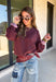 A cozy sweater with a little extra personality! This rich plum sweater features contrasting mauve exposed hems that add a soft, lived-in touch to the classic silhouette. The ribbed hem and sleeves create a comfortable fit while giving the sweater just the right amount of texture. Easy to style and perfect for chilly days, this cozy knit will quickly become a favorite for coffee runs, casual weekends, and fall outings.