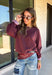A cozy sweater with a little extra personality! This rich plum sweater features contrasting mauve exposed hems that add a soft, lived-in touch to the classic silhouette. The ribbed hem and sleeves create a comfortable fit while giving the sweater just the right amount of texture. Easy to style and perfect for chilly days, this cozy knit will quickly become a favorite for coffee runs, casual weekends, and fall outings.