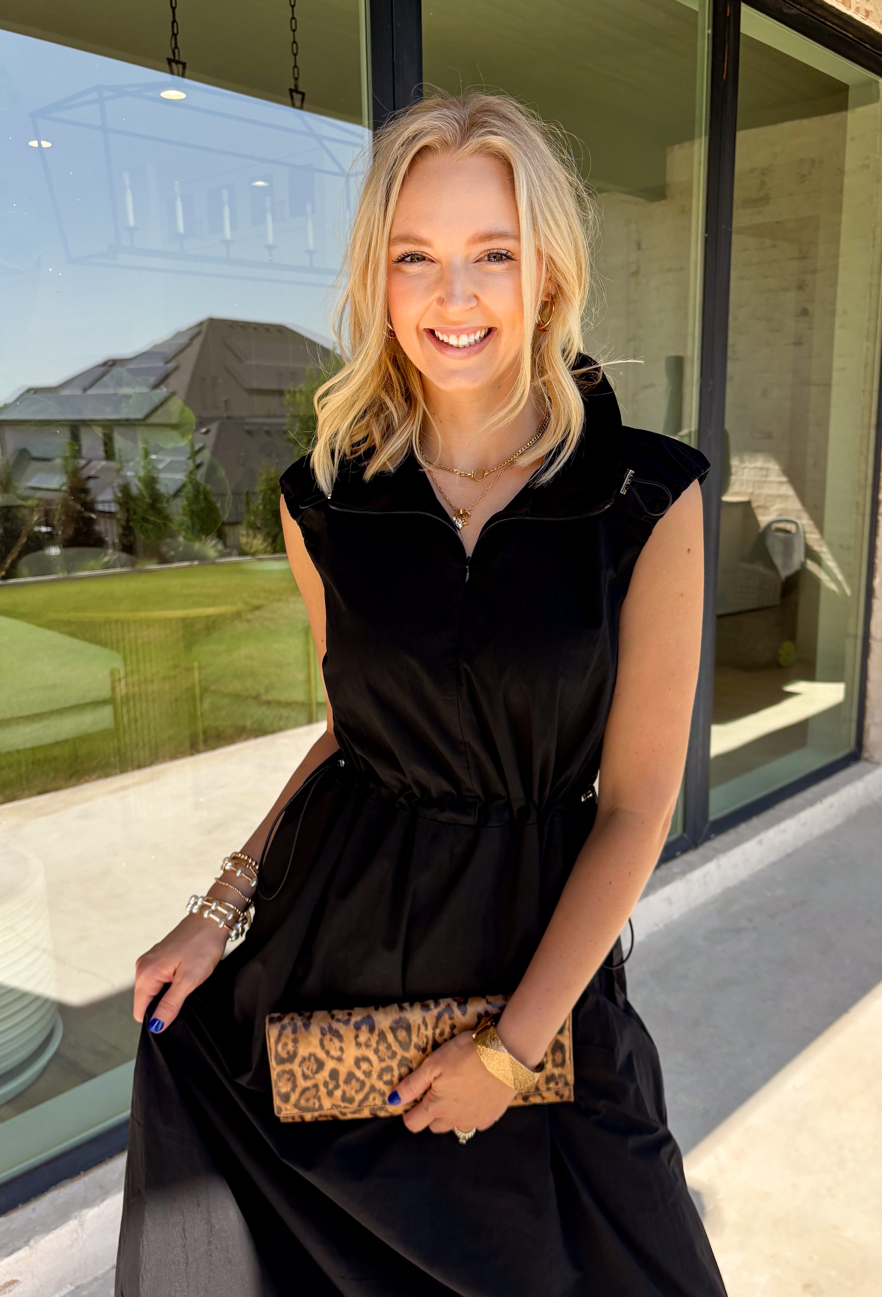 Meet your new throw-on-and-go favorite with this black utility-inspired midi dress from Entro. The classic black color keeps it versatile, while the zipper-front closure and adjustable waist give it a sporty, modern feel. A bubble hem adds shape and a fun unexpected finish, while the sleeveless silhouette makes it easy to wear now and layer as the temperatures cool down. Complete with convenient side pockets, this dress is ready for busy workdays, weekend plans, travel days, and everything in between.