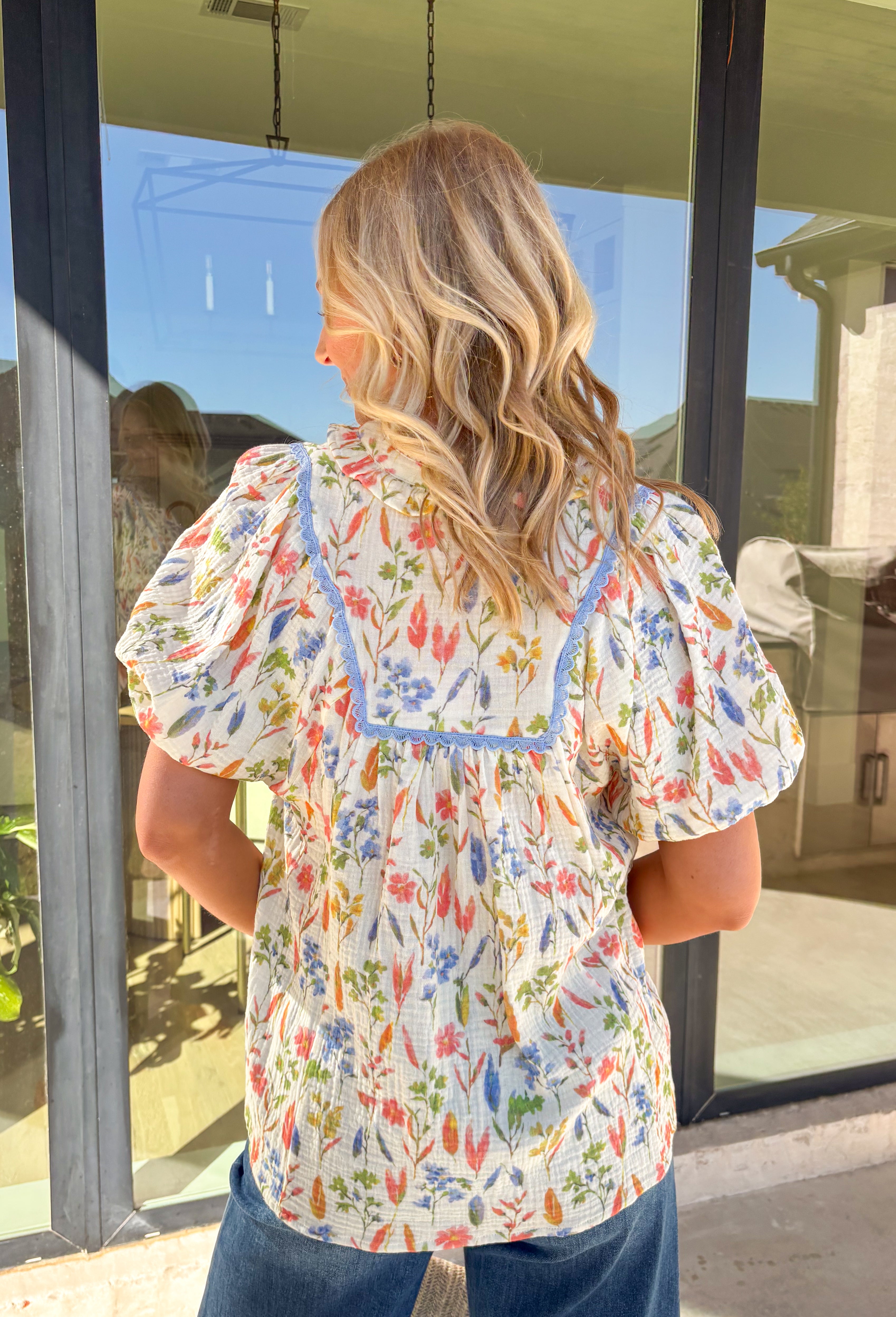 Fresh, feminine, and perfect for spring days, this cream gauze top by Umgee is full of cheerful charm. Featuring a colorful floral print in pink, green, and blue, this lightweight cotton top feels breezy and effortless. The blue scallop lace trim along the front adds a sweet detail, while the ruffled neckline and elastic cuff sleeves give it a soft, romantic finish that’s easy to wear all season long.