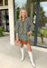 Chic and full of seasonal charm, this hunter green mini dress by Entro brings a fresh take on winter dressing. Featuring a geometric print in tan, white, brown, and lavender, it adds a modern twist to your cold-weather wardrobe. The contrast binding and ruffle hem offer feminine flair, while the lined design and side pocket make it as comfortable as it is stylish.