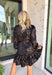 Bring a little shimmer to the season with this black long sleeve dress. Designed with a subtle leopard print in a textured, metallic-like finish, it adds depth and shine without being over the top. A button-down front and ruffle trim soften the look, making it equal parts chic and feminine. Lightweight yet lined, this dress is a perfect choice for special occasions, evening dinners, or holiday gatherings.