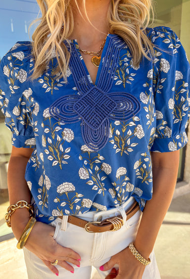 Easygoing with a touch of boho charm, this blue short sleeve top by Entro is perfect for laid-back spring days. Featuring a floral print with fresh pops of green, it is the perfect spring top. The macramé-style rope detailing along the top adds beautiful texture and a relaxed, artisan feel that makes this piece stand out while still being easy to wear. Lightweight cotton keeps it comfortable and breathable all season long.