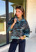 A dusty blue background gives this cozy knit sweater from Entro a fresh pop of color for the season. The darker abstract animal print creates a bold contrast against the dusty blue shade, adding plenty of personality without being difficult to style. A stand neckline and partial button-front closure bring a classic touch to the relaxed knit silhouette, while the ¾ sleeves make it a great option for transitional weather. 