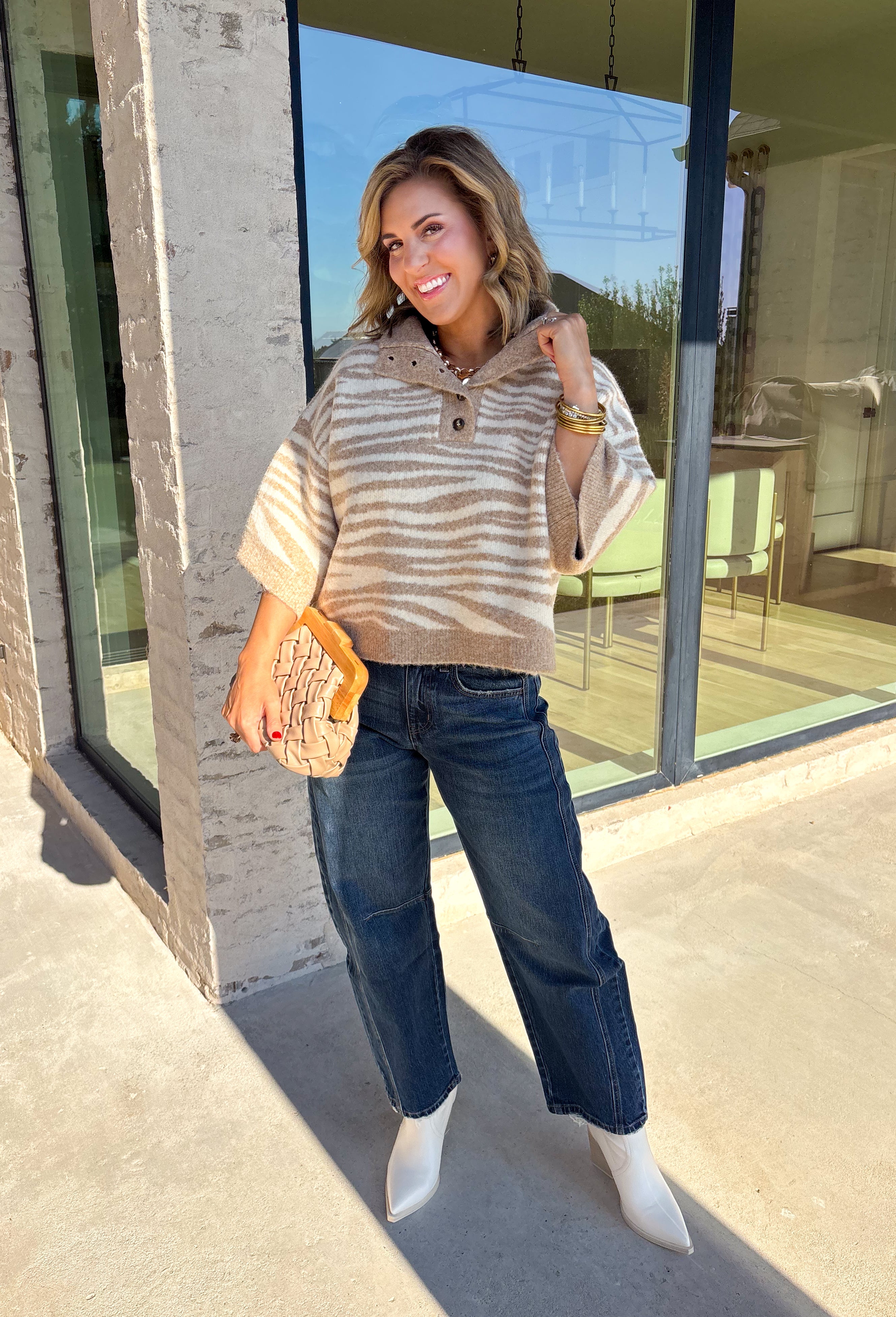 A neutral animal print gives this cozy knit top from Entro plenty of personality while keeping it easy to mix into your fall wardrobe. The abstract pattern brings together versatile neutral shades for a fresh take on a classic animal print. A stand neckline and partial button-front closure add structure to the relaxed knit silhouette, while the ¾ sleeves make it a great choice for those in-between weather days. 