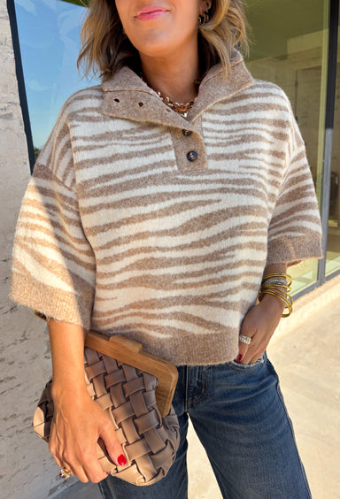 A neutral animal print gives this cozy knit top from Entro plenty of personality while keeping it easy to mix into your fall wardrobe. The abstract pattern brings together versatile neutral shades for a fresh take on a classic animal print. A stand neckline and partial button-front closure add structure to the relaxed knit silhouette, while the ¾ sleeves make it a great choice for those in-between weather days. 