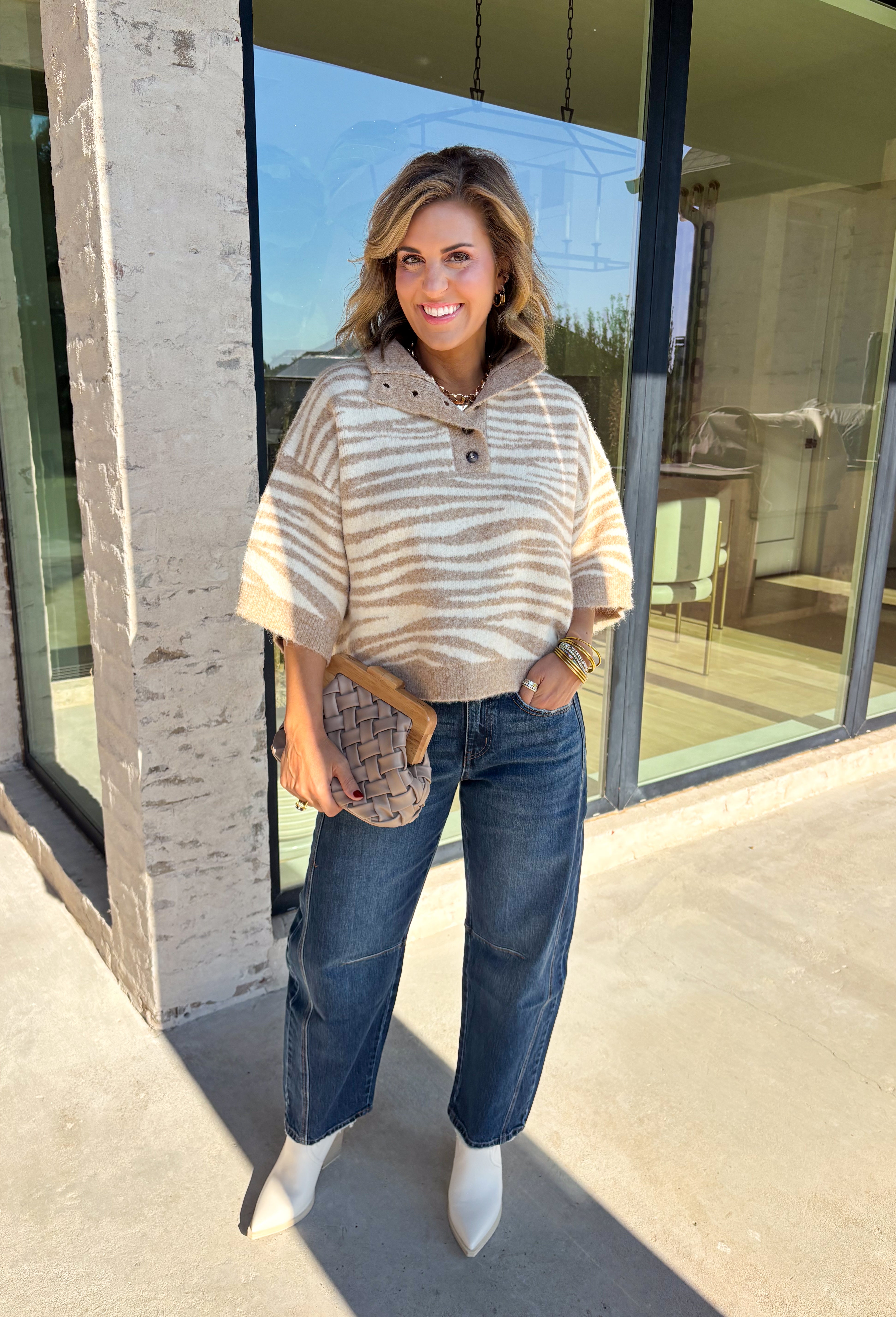 A neutral animal print gives this cozy knit top from Entro plenty of personality while keeping it easy to mix into your fall wardrobe. The abstract pattern brings together versatile neutral shades for a fresh take on a classic animal print. A stand neckline and partial button-front closure add structure to the relaxed knit silhouette, while the ¾ sleeves make it a great choice for those in-between weather days. 