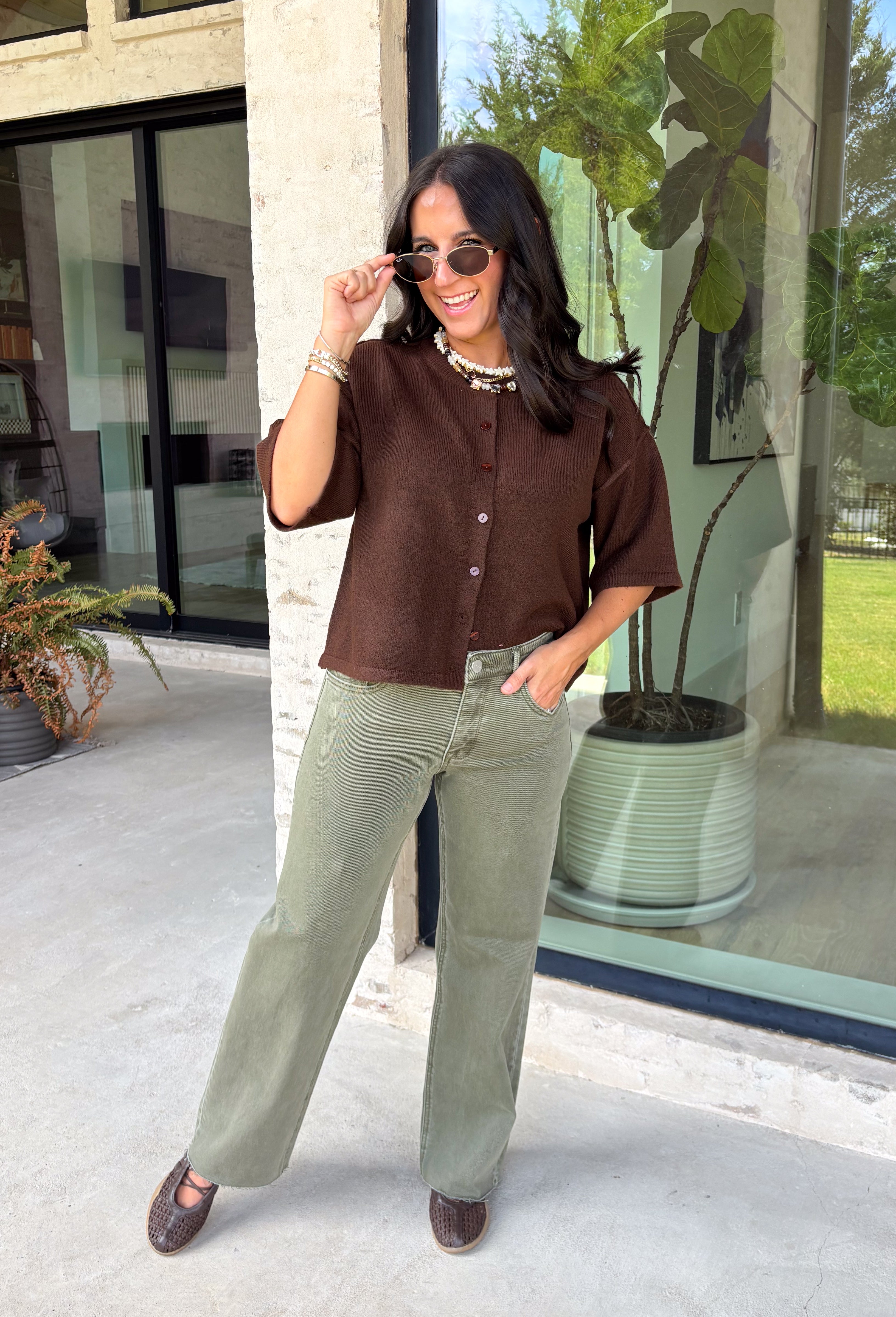 Cozy, classic, and endlessly versatile, this button-down cardigan from Double Zero is the perfect layering piece for the season. Designed in a rich dark brown hue, this soft knit cardigan is easy to style with everything from denim to dresses. The ribbed neckline adds a timeless touch, while the cozy knit construction keeps you comfortable throughout the day. Wear it buttoned as a sweater or open over your favorite basics for an effortlessly polished fall look.