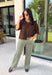 Cozy, classic, and endlessly versatile, this button-down cardigan from Double Zero is the perfect layering piece for the season. Designed in a rich dark brown hue, this soft knit cardigan is easy to style with everything from denim to dresses. The ribbed neckline adds a timeless touch, while the cozy knit construction keeps you comfortable throughout the day. Wear it buttoned as a sweater or open over your favorite basics for an effortlessly polished fall look.