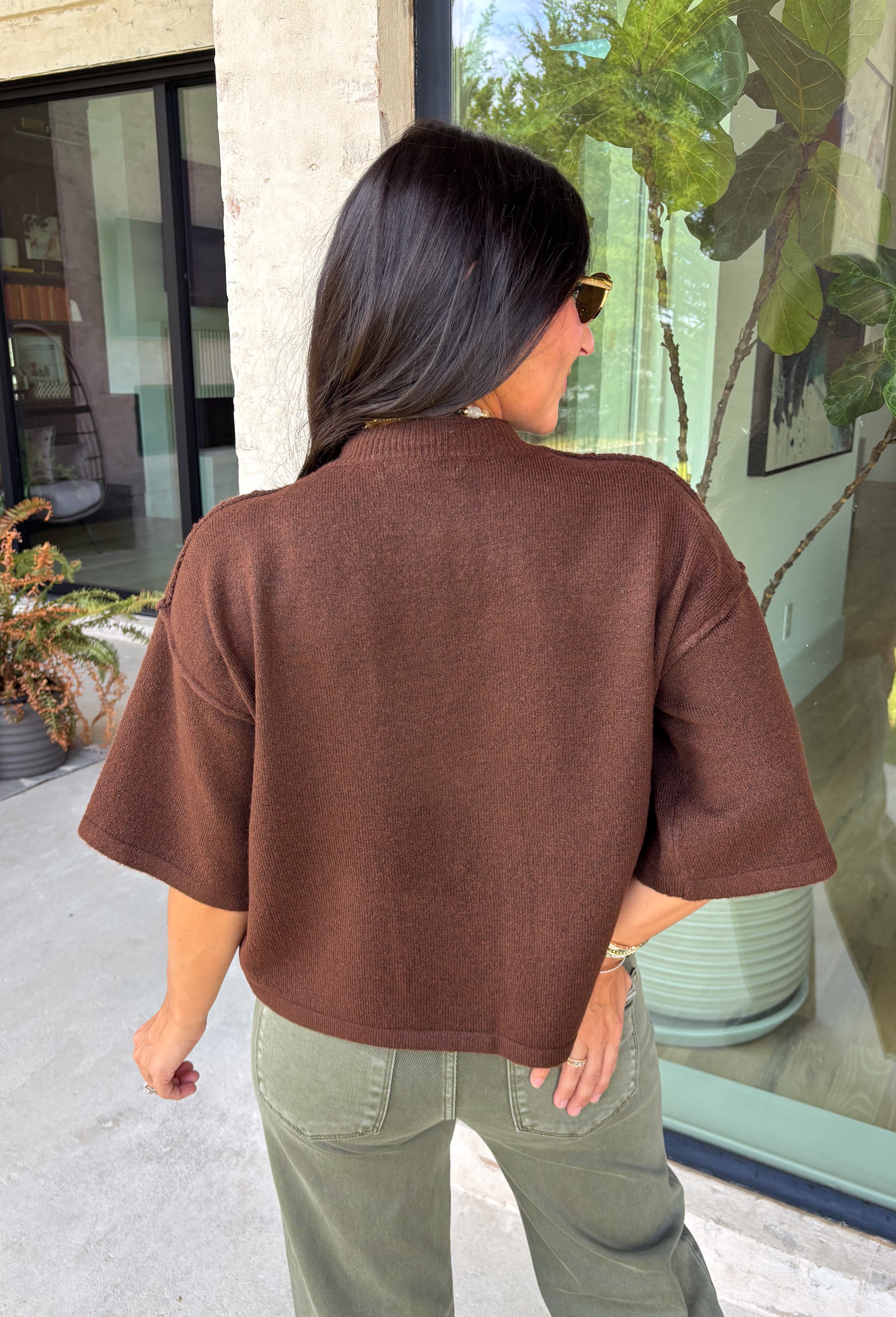 Cozy, classic, and endlessly versatile, this button-down cardigan from Double Zero is the perfect layering piece for the season. Designed in a rich dark brown hue, this soft knit cardigan is easy to style with everything from denim to dresses. The ribbed neckline adds a timeless touch, while the cozy knit construction keeps you comfortable throughout the day. Wear it buttoned as a sweater or open over your favorite basics for an effortlessly polished fall look.