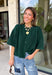 Cozy, classic, and endlessly versatile, this button-down cardigan from Double Zero is the perfect layering piece for the season. Designed in a rich dark green hue, this soft knit cardigan is easy to style with everything from denim to dresses. The ribbed neckline adds a timeless touch, while the cozy knit construction keeps you comfortable throughout the day. Wear it buttoned as a sweater or open over your favorite basics for an effortlessly polished fall look.