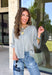 Cozy, classic, and endlessly versatile, this button-down cardigan from Double Zero is the perfect layering piece for the season. Designed in a heather grey hue, this soft knit cardigan is easy to style with everything from denim to dresses. The ribbed neckline adds a timeless touch, while the cozy knit construction keeps you comfortable throughout the day. Wear it buttoned as a sweater or open over your favorite basics for an effortlessly polished fall look.