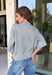 Cozy, classic, and endlessly versatile, this button-down cardigan from Double Zero is the perfect layering piece for the season. Designed in a heather grey hue, this soft knit cardigan is easy to style with everything from denim to dresses. The ribbed neckline adds a timeless touch, while the cozy knit construction keeps you comfortable throughout the day. Wear it buttoned as a sweater or open over your favorite basics for an effortlessly polished fall look.