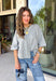 Cozy, classic, and endlessly versatile, this button-down cardigan from Double Zero is the perfect layering piece for the season. Designed in a heather grey hue, this soft knit cardigan is easy to style with everything from denim to dresses. The ribbed neckline adds a timeless touch, while the cozy knit construction keeps you comfortable throughout the day. Wear it buttoned as a sweater or open over your favorite basics for an effortlessly polished fall look.