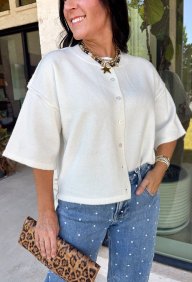 Cozy, classic, and endlessly versatile, this button-down cardigan from Double Zero is the perfect layering piece for the season. Designed in a neutral whip cream hue, this soft knit cardigan is easy to style with everything from denim to dresses. The ribbed neckline adds a timeless touch, while the cozy knit construction keeps you comfortable throughout the day. Wear it buttoned as a sweater or open over your favorite basics for an effortlessly polished fall look.