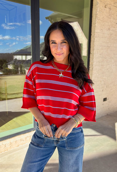 Bold, breezy, and perfect for spring layering, this striped knit top by Entro brings an easy pop of color to your everyday look. Featuring red and light blue stripes with a relaxed drop shoulder fit, it feels laid-back yet polished. The ribbed neckline, cuffs, and hem add subtle structure, while the cropped length keeps it fun and on-trend. Lightweight and comfortable, it’s an easy piece to style all season long.