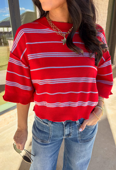 Bold, breezy, and perfect for spring layering, this striped knit top by Entro brings an easy pop of color to your everyday look. Featuring red and light blue stripes with a relaxed drop shoulder fit, it feels laid-back yet polished. The ribbed neckline, cuffs, and hem add subtle structure, while the cropped length keeps it fun and on-trend. Lightweight and comfortable, it’s an easy piece to style all season long.