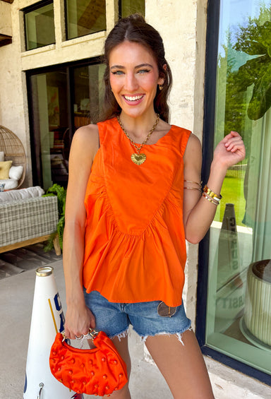 This orange sleeveless top is the versatile staple your wardrobe needs all year long! The vibrant color makes it a standout choice for game day season, while the clean, classic silhouette ensures you'll wear it far beyond football weekends. Designed with a high round neckline and a simple keyhole button closure in the back, it has an elevated look that's easy to dress up or down.